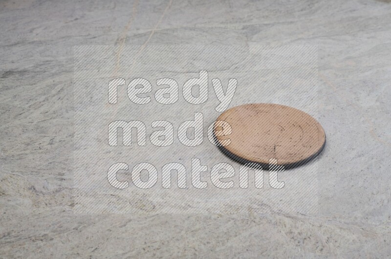 A flat pottery plate on grey marble background