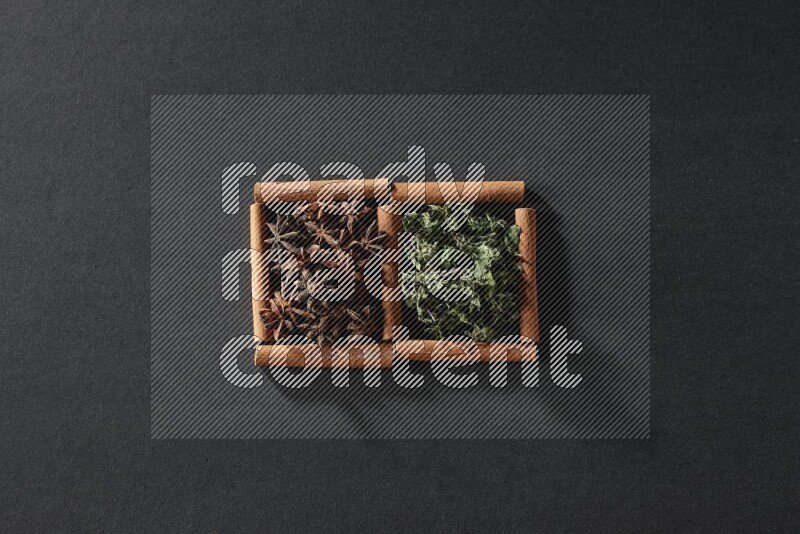 2 squares of cinnamon sticks full of star anise and dried mint leaves on black flooring