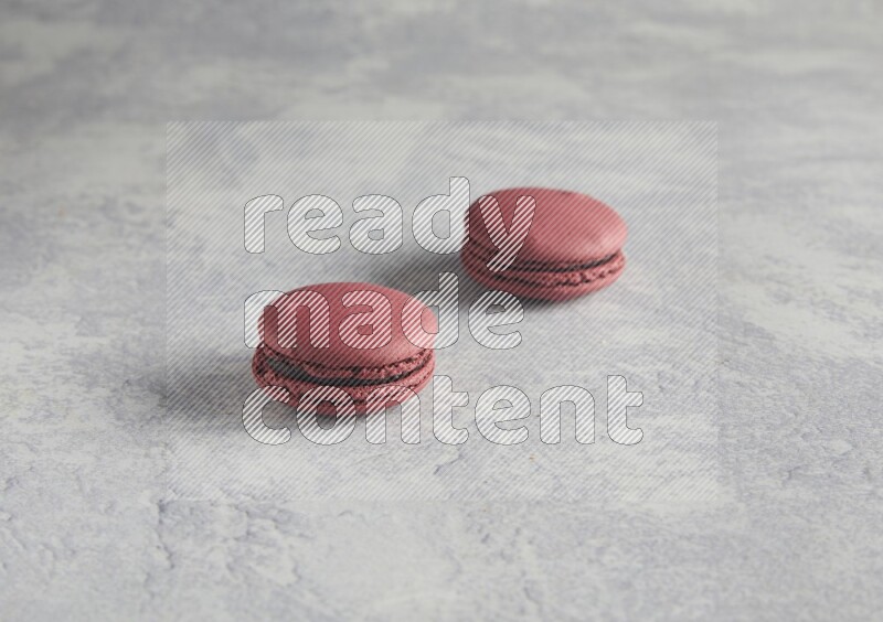45º Shot of two Red Cherry macarons  on white  marble background