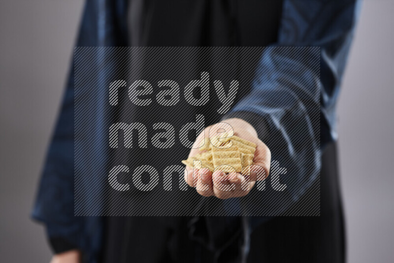 Woman in abaya holding different kinds of snacks in different positions