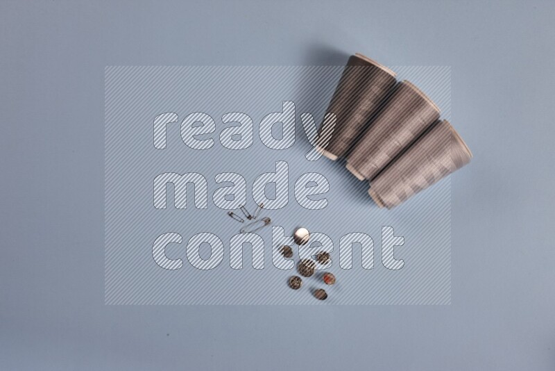 A grey collection of sewing and tailoring tools arranged on a blue background