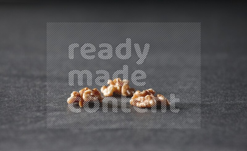 3 walnuts on a black background in different angles