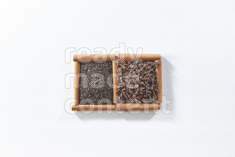 2 squares of cinnamon sticks full of black tea and cloves on white flooring
