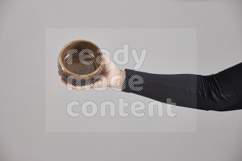 A woman in black abaya holding different pottery essentials in different positions