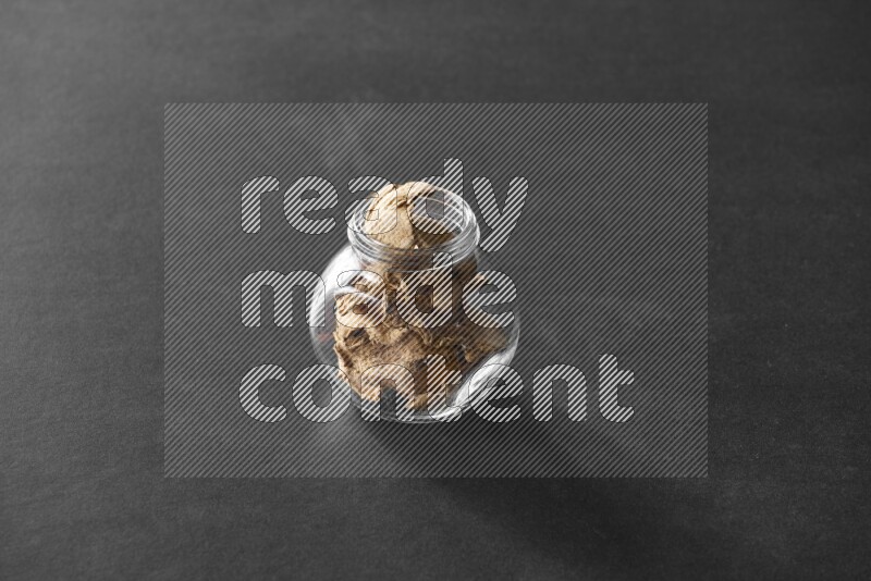 زنجبيل مجفف في وعاء زجاجي علي خلفية سوداء