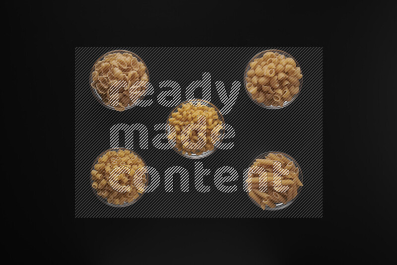 أنواع مختلفة من المعكرونة في أوعية زجاجية علي خلفية سوداء