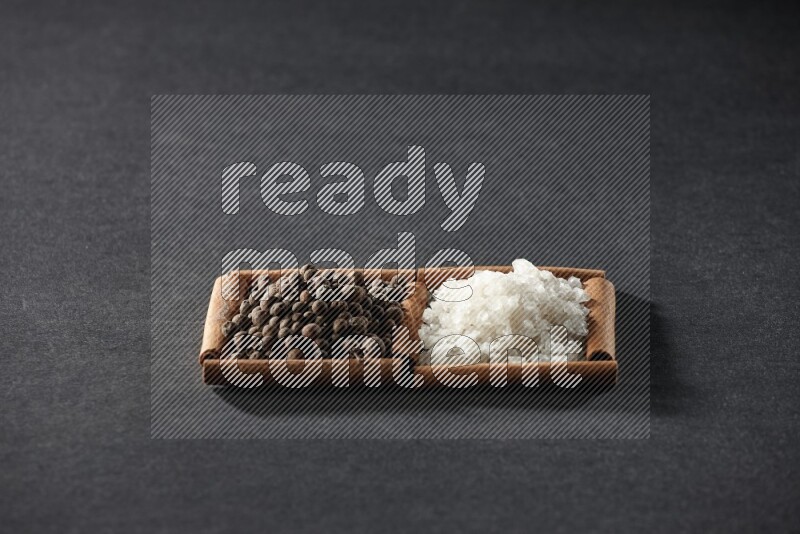 2 squares of cinnamon sticks full of white salt and allspice on black flooring