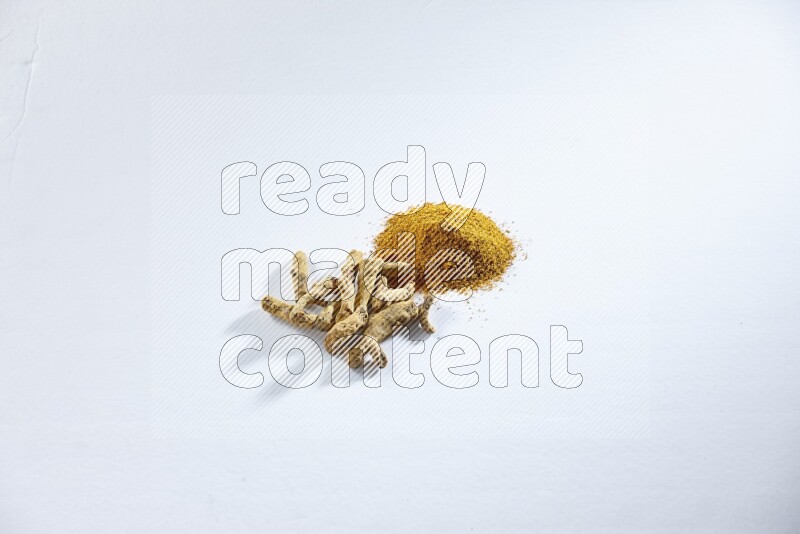 بودرة الكركم وأصابع الكركم المجففة على خلفية بيضاء