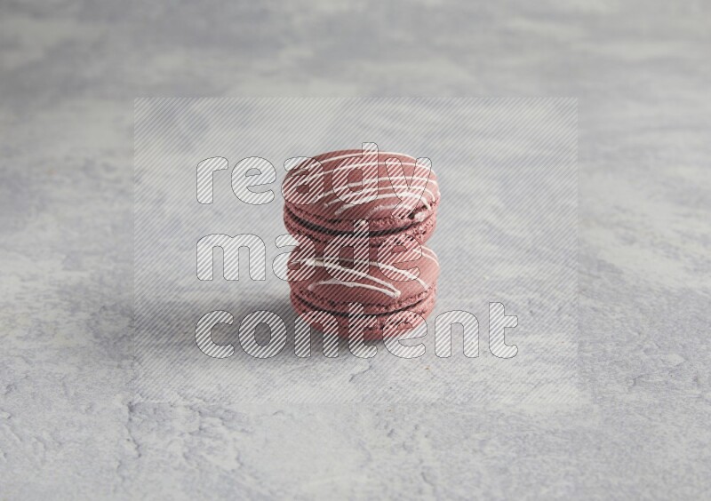 45º Shot of two Red Poppy Flower macarons on white  marble background
