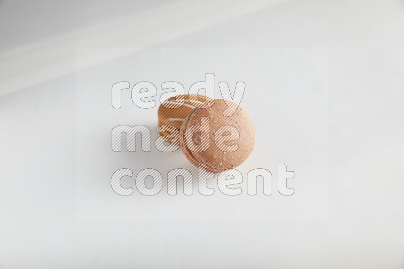 45º Shot of of two assorted Brown Irish Cream, and Brown Hazelnuts macarons on white background