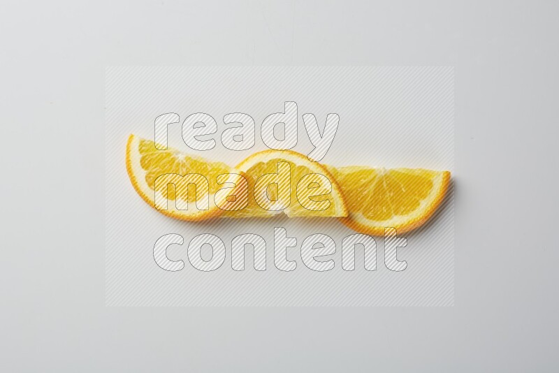 Three halves of an orange slices on white background