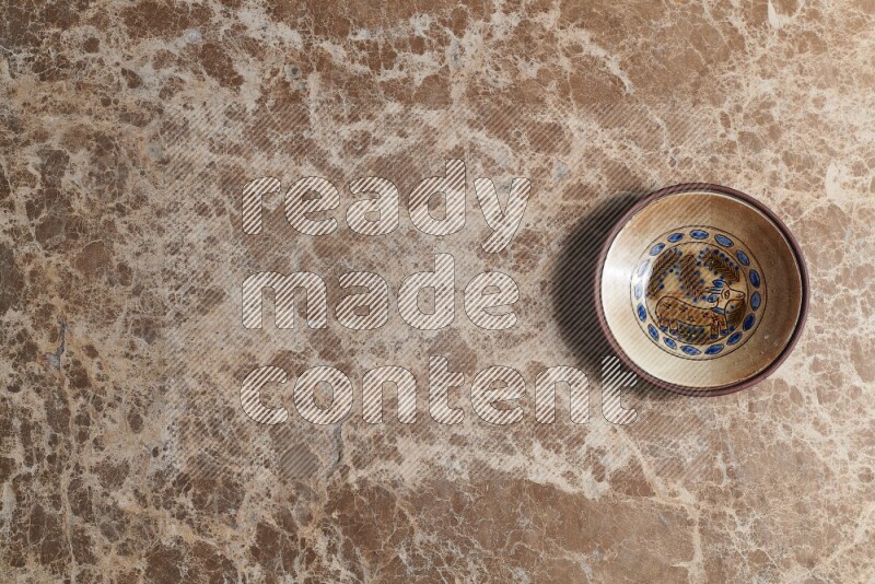 A decorative pottery plate on beige marble background