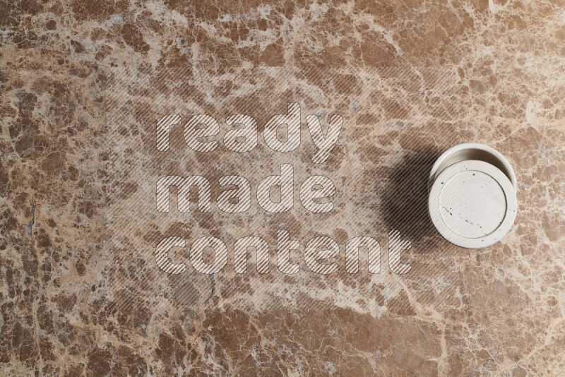 A pottery cup on beige marble background