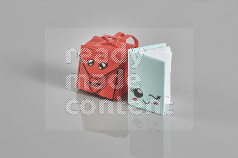 Origami school supplies such as back bag, books and ruler on grey background