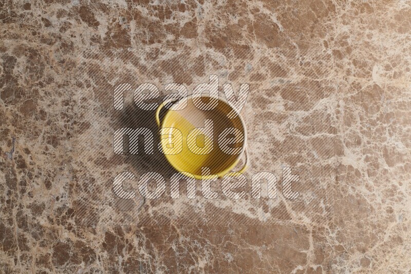 A multicolored pottery bowl on beige marble background
