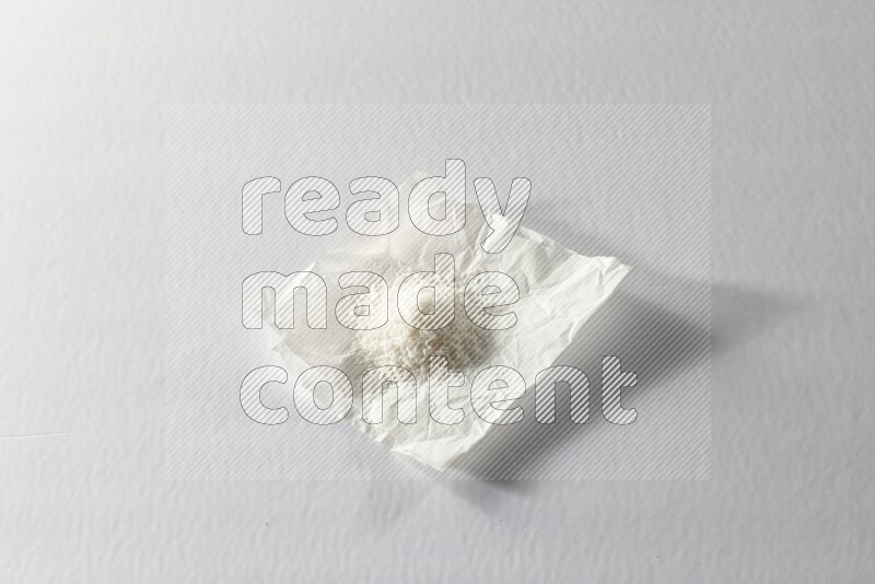 Desiccated coconut on a piece of paper on a white background in different angles