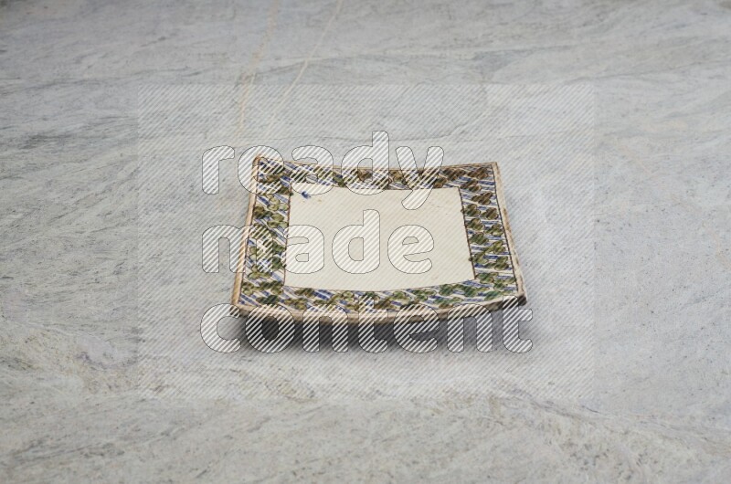 A decorative pottery plate on grey marble background