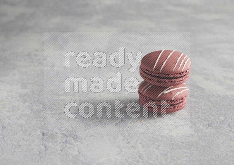45º Shot of two Red Poppy Flower macarons on white  marble background
