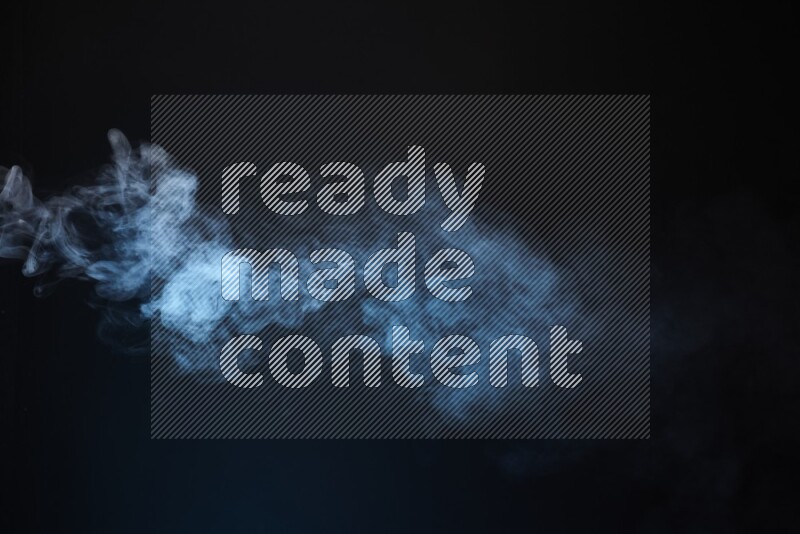 Heavy smoke in blue isolated on black background
