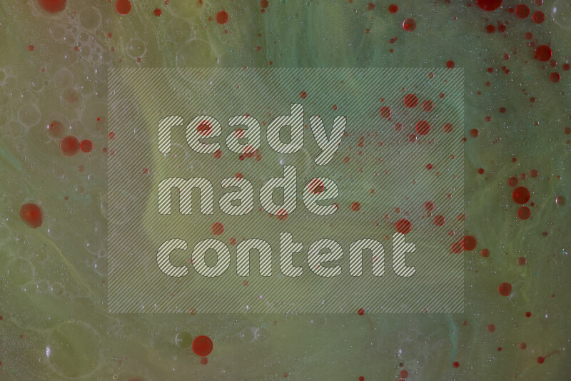 The image captures a dramatic splatter of red paint over a green backdrop