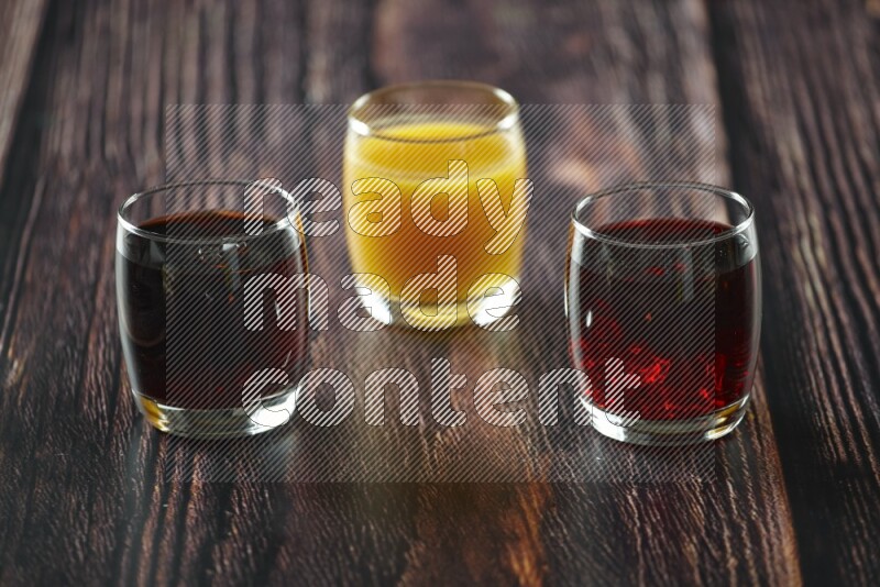 Cold drinks in a glass cup such as water, tamarind, qamar eldin, sobia, milk and hibiscus on wooden background