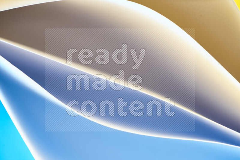 This image showcases an abstract paper art composition with paper curves in blue and yellow gradients created by colored light