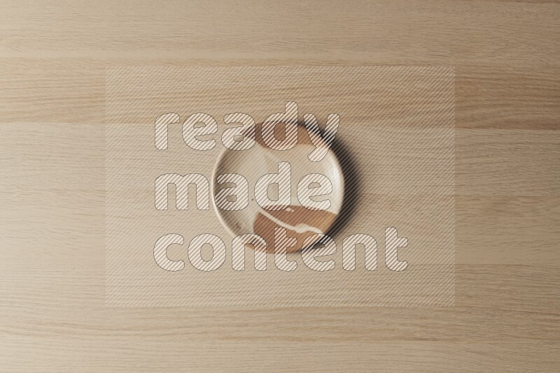 A multicolored pottery plate on light wooden background