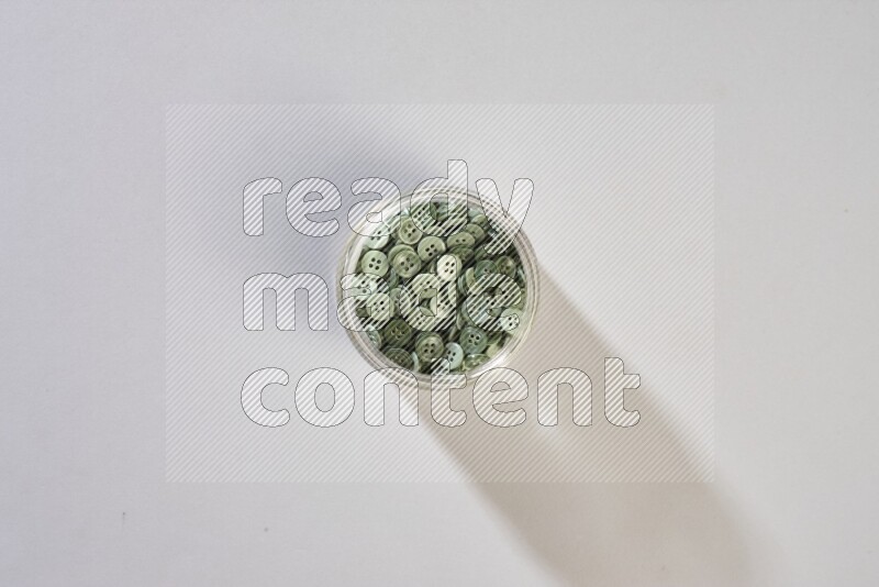 Colored buttons in a glass jar on grey background