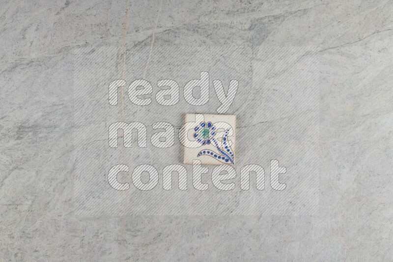 A decorative pottery coaster on grey marble background