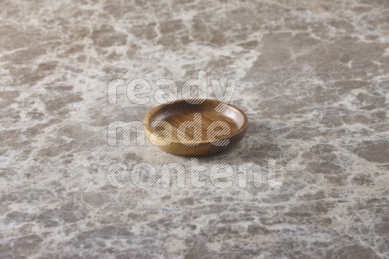 A wooden bowl on beige marble background