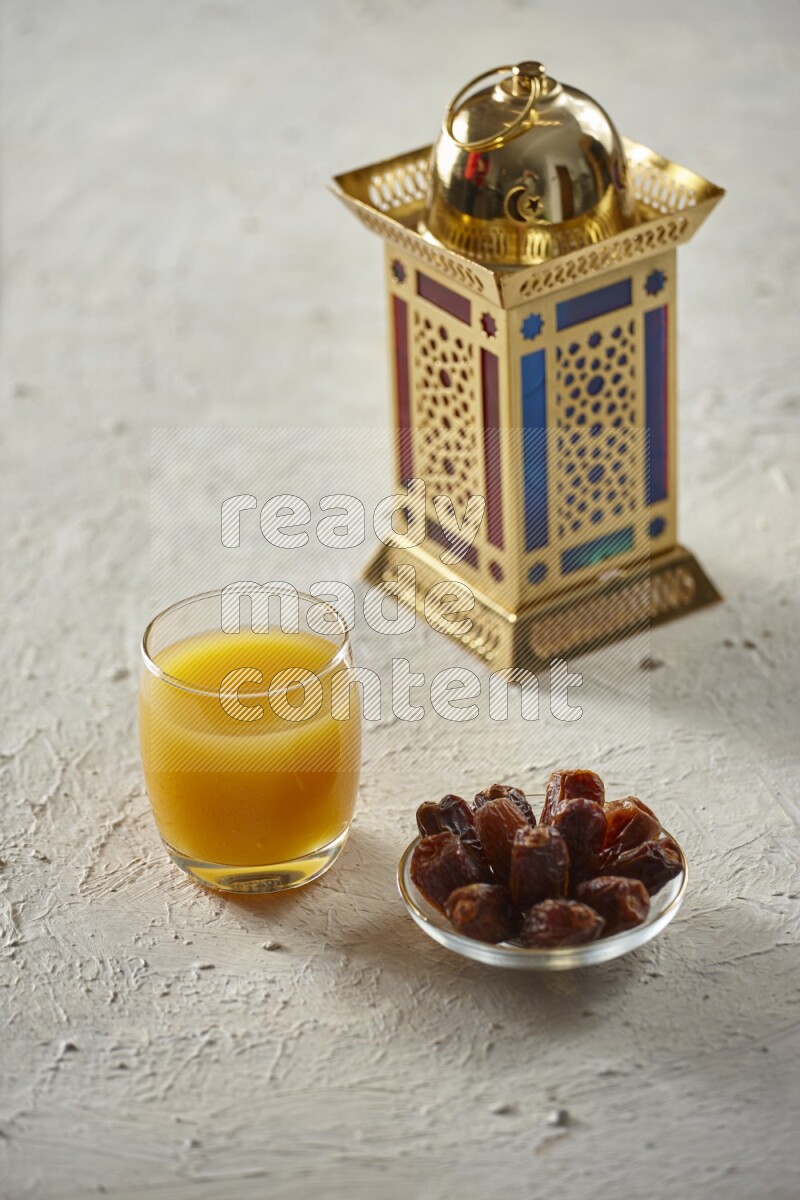 A golden lantern with different drinks, dates, nuts, prayer beads and quran on textured white background