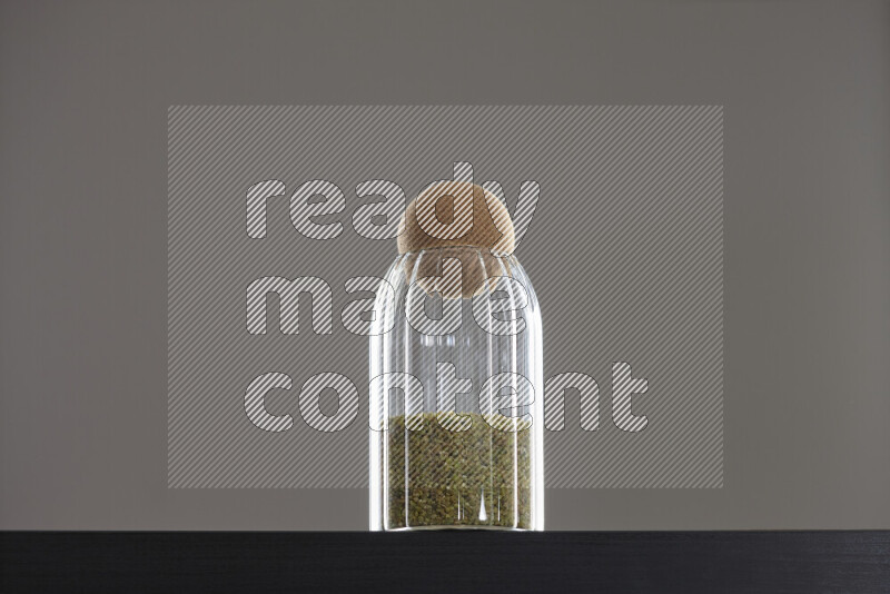 Freekeh in a glass jar on black background