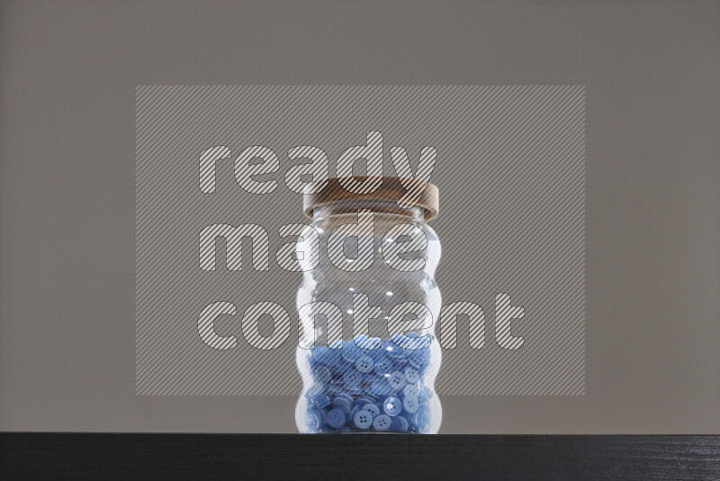 Buttons in a glass jar on black background