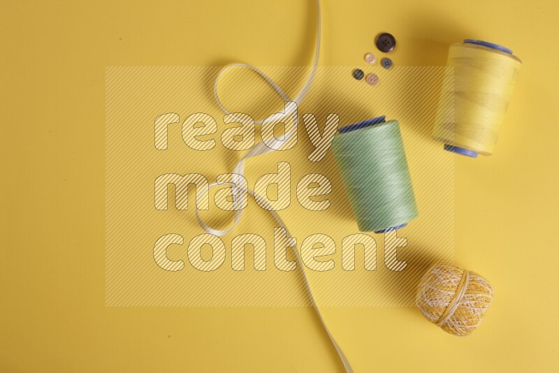 A green collection of sewing and tailoring tools arranged on a yellow background
