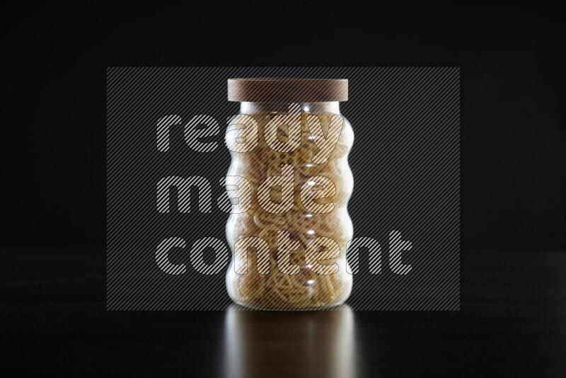 Snacks in a glass jar on black background