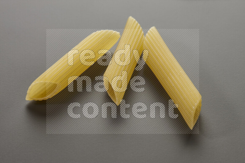 Penne pasta on grey background