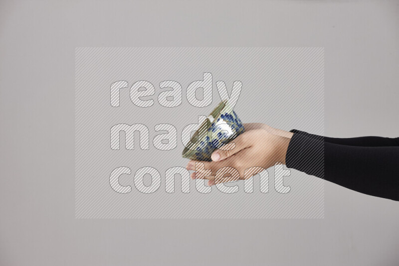 امرأة ترتدي عباءة سوداء تحمل أدوات فخارية مختلفة في أوضاع متعددة