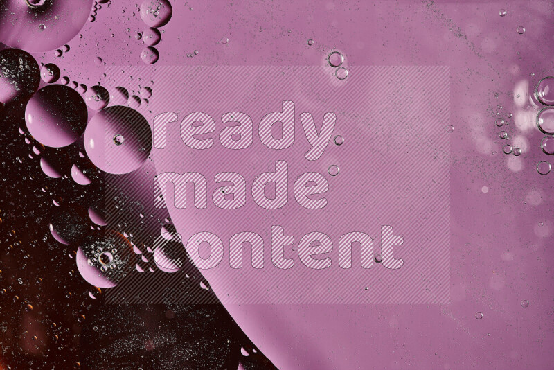 لقطات مقربة لفقاعات من الزيت على سطح الماء باللون البرتقالي والأرجواني