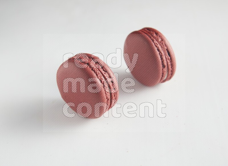 45º Shot of two Red Velvet macarons on white background