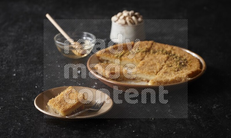 Konafa with nuts and honey in a dark setup