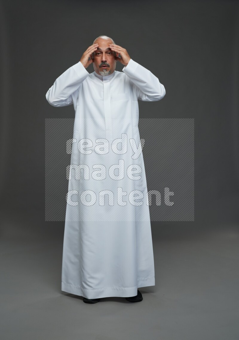 Saudi man without shomag Standing Interacting with the camera on gray background