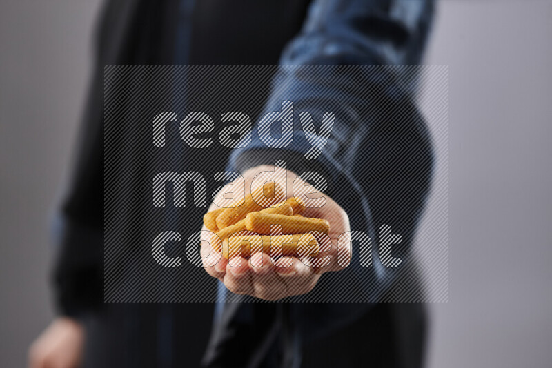 Woman in abaya holding different kinds of snacks in different positions