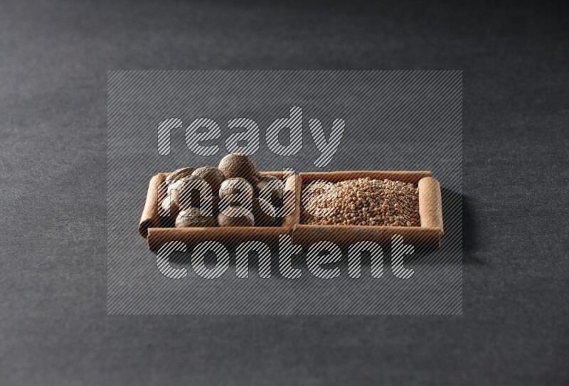 2 squares of cinnamon sticks full of mustard seeds and nutmeg on black flooring