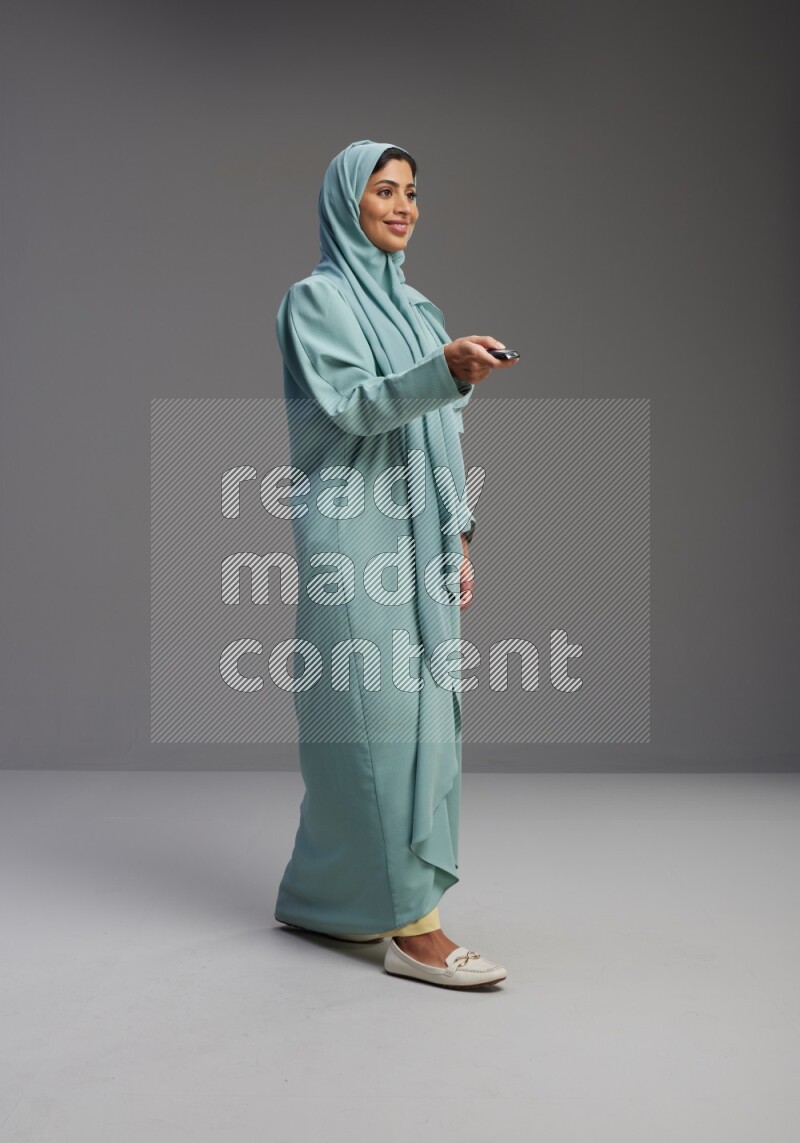 Saudi Woman wearing Abaya standing holding car key on Gray background