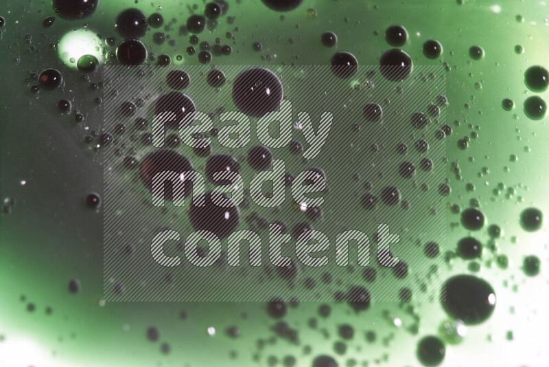 لقطات مقربة لقطرات ألوان مائية خضراء على سطح الزيت على خلفية بيضاء