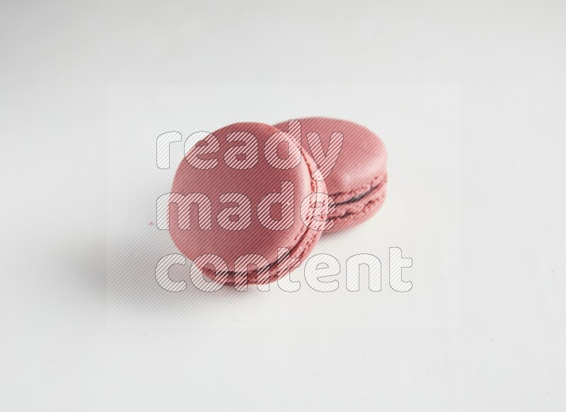 45º Shot of two Pink Raspberry macarons on white background