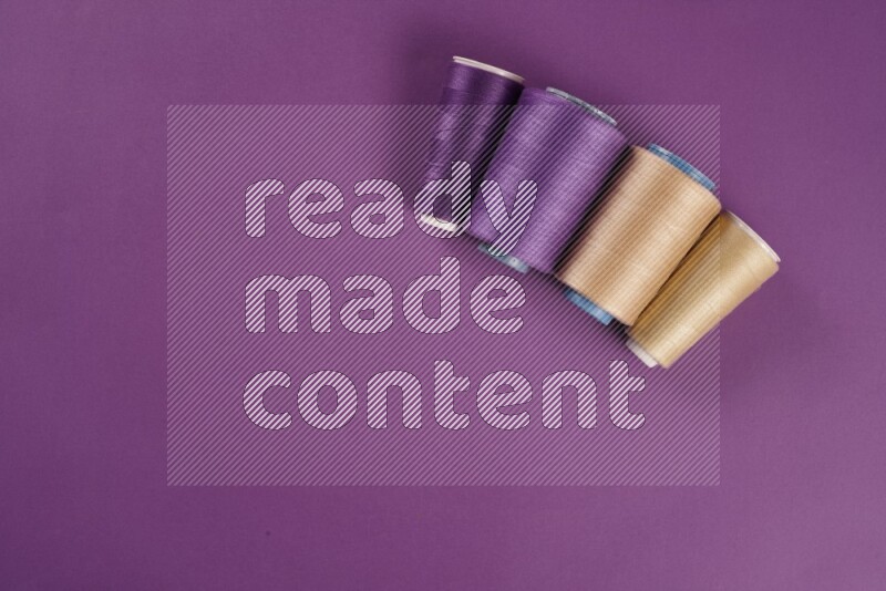 A beige collection of sewing and tailoring tools arranged on a purple background