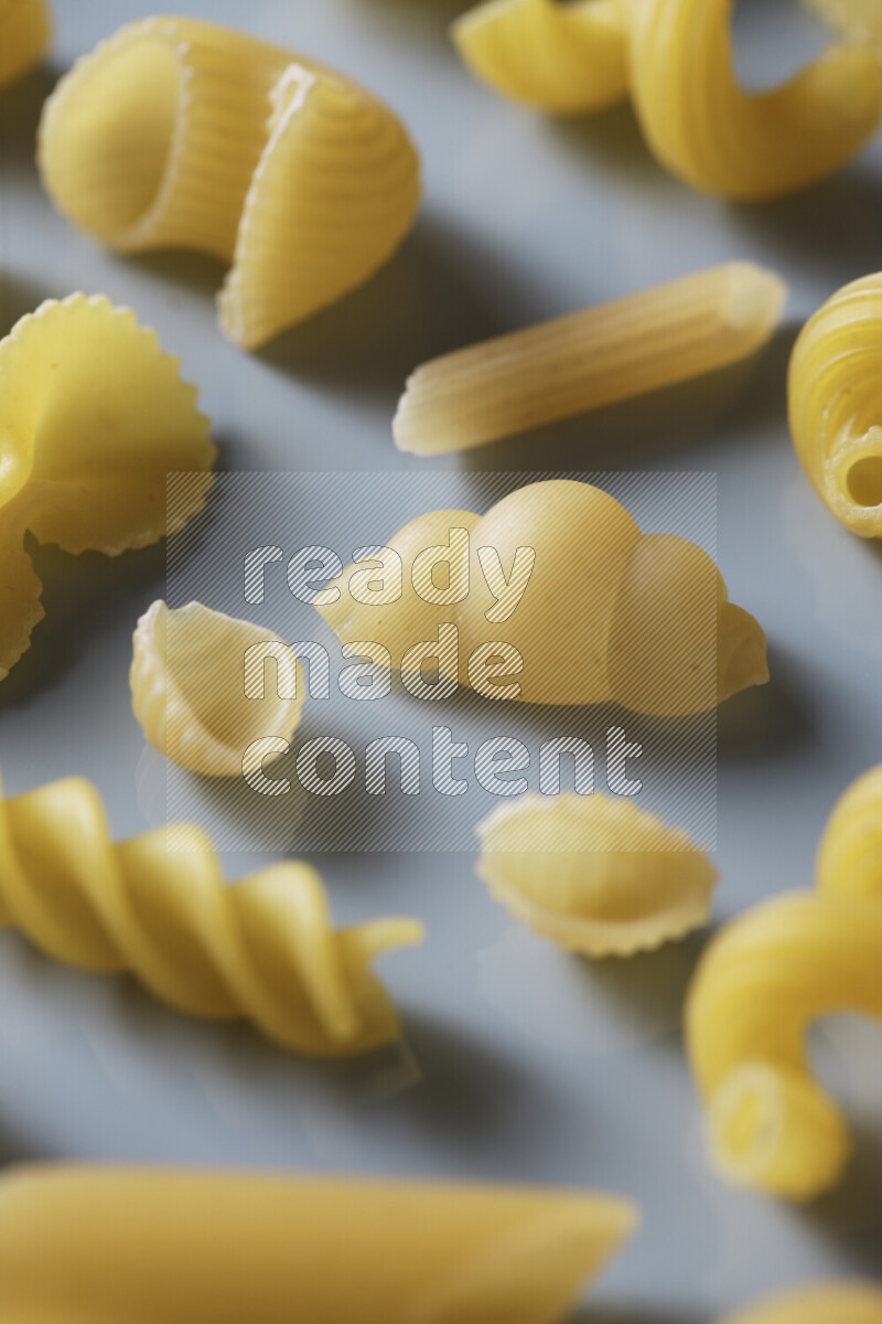 Different pasta types on light blue background