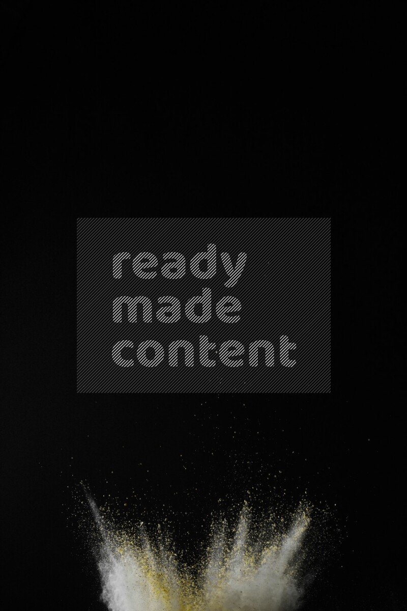 A side view of yellow powder explosion on black background