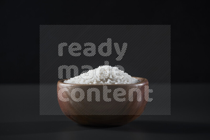 White rice in a wooden bowl on grey background